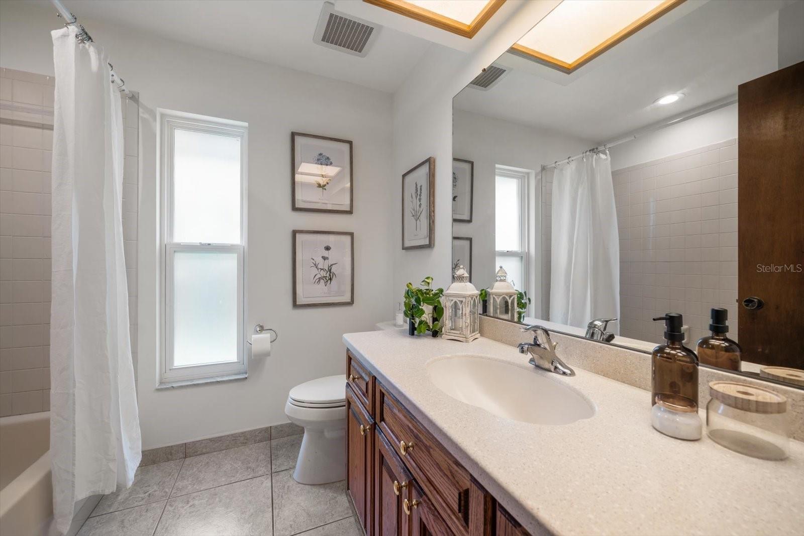 The PERFECT guest bathroom with large vanity, bright natural light and a tub/shower combo.