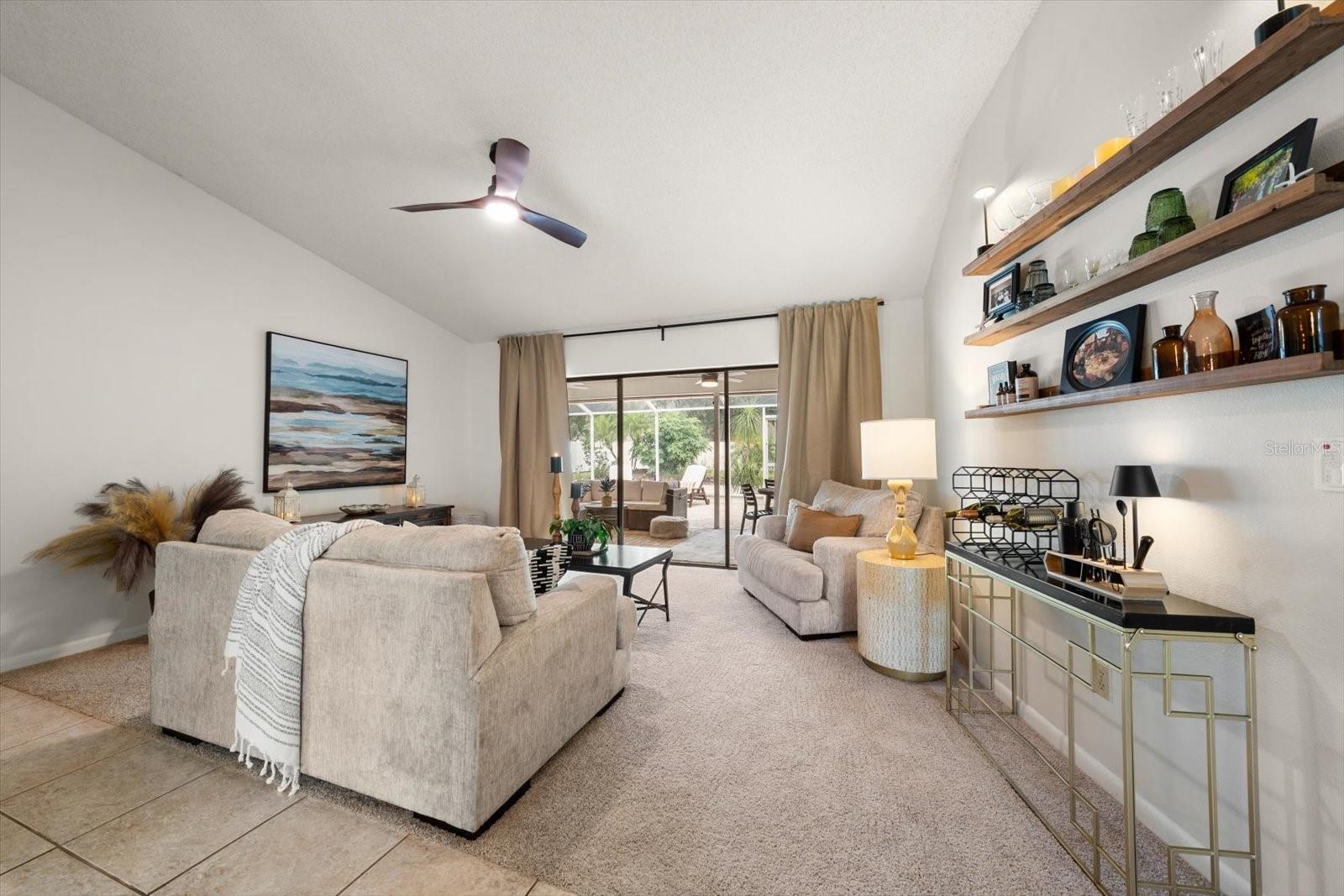 Formal living spaces have a panoramic view of the paved and covered lanai.
