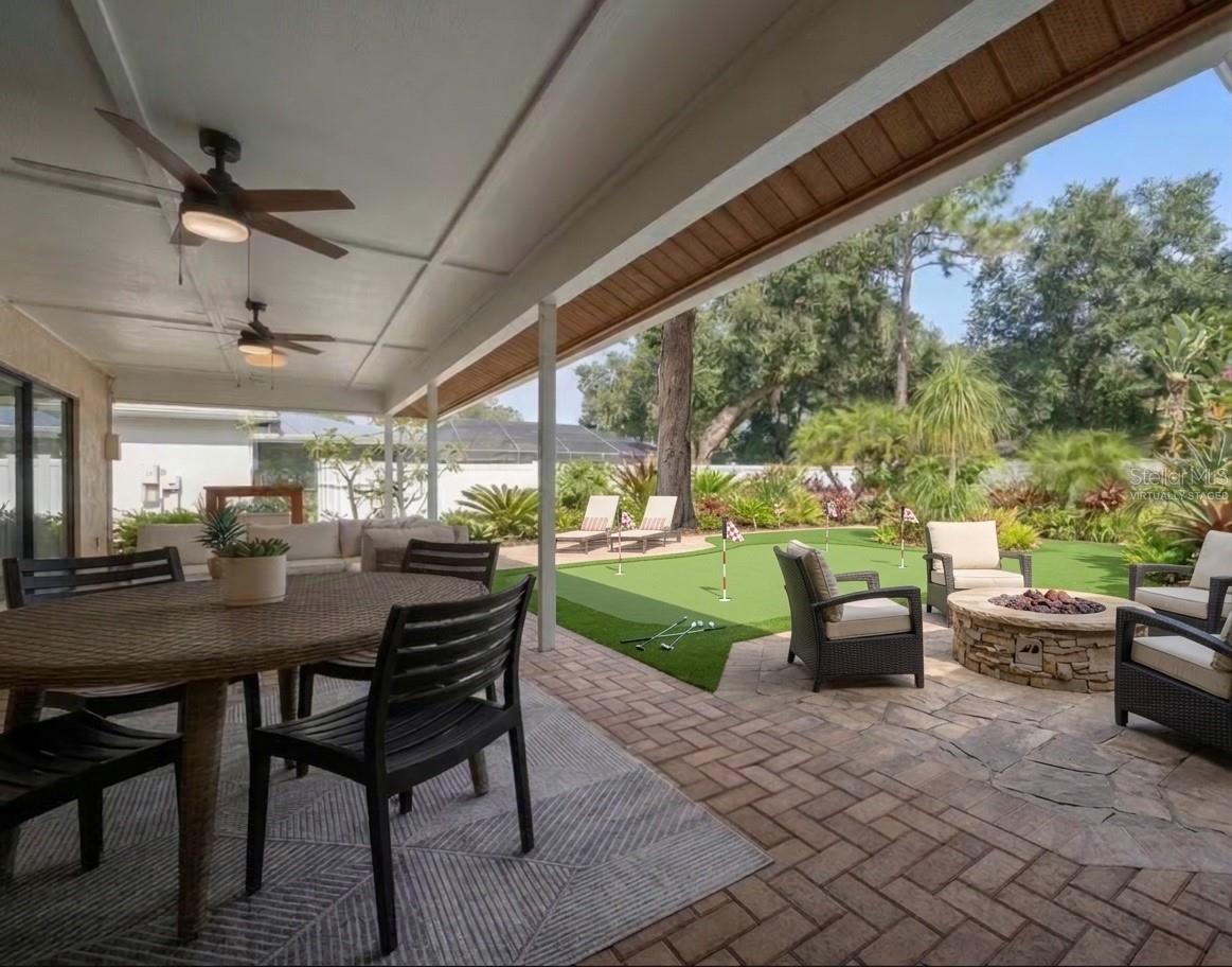 Looking out from patio with virtually staged fire-pit and putting green.