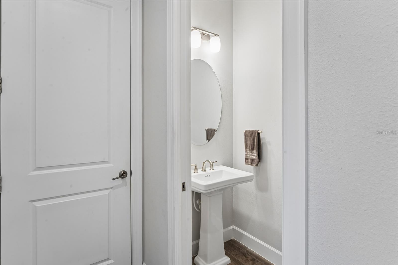 Half bath in hallway leading out to garage