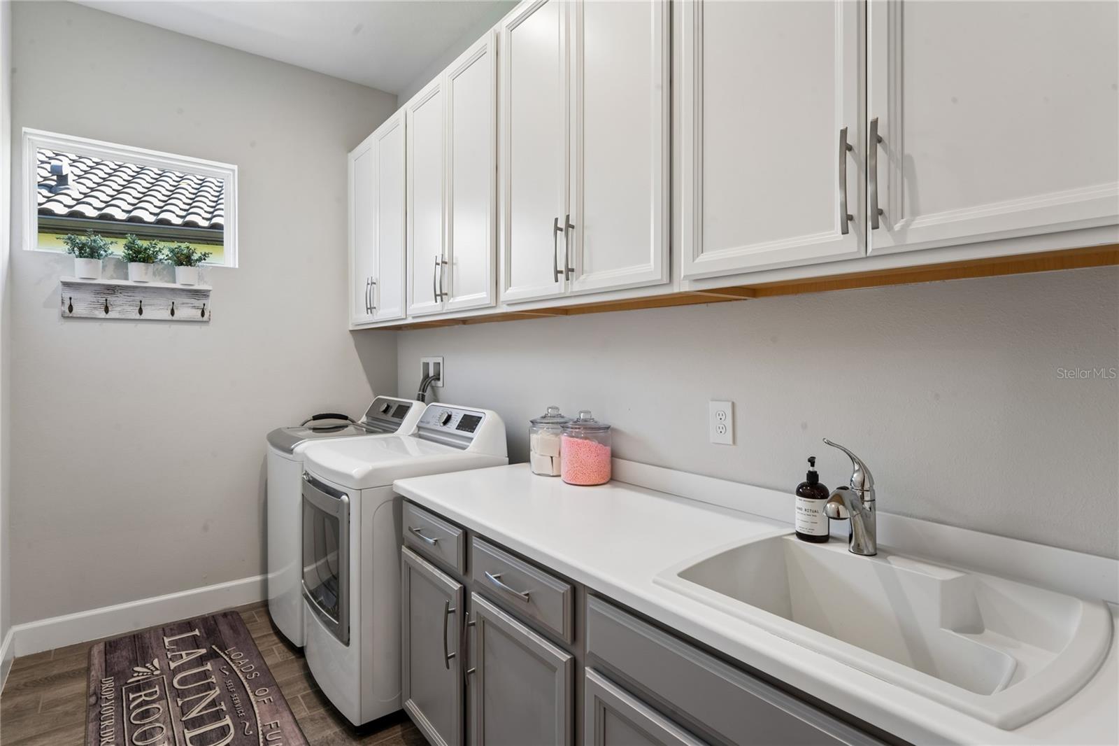 Laundry room with storage cabinets and utility sink