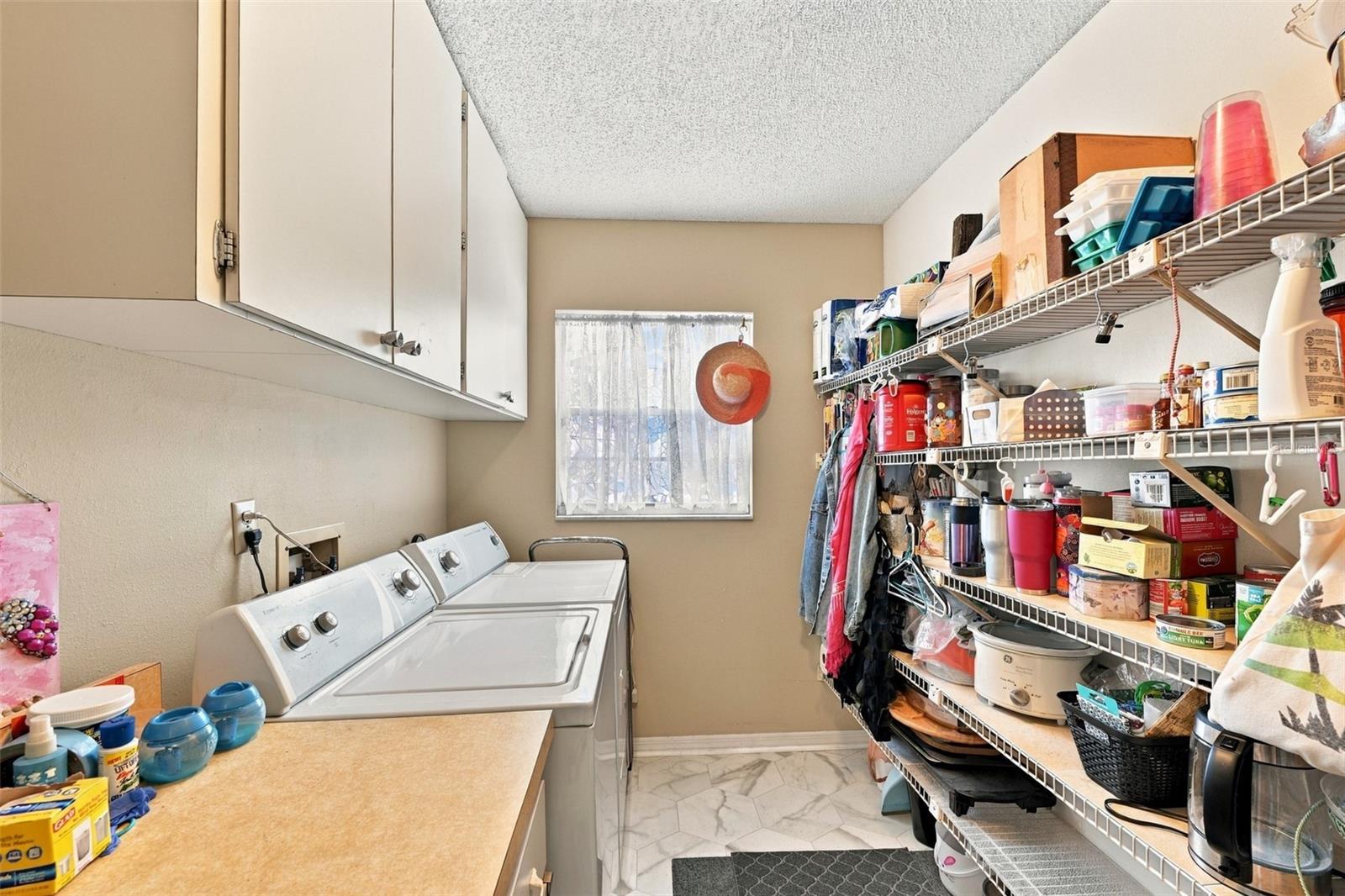 The inside laundry room has lots of storage and cabinetry with new windows for natural sunshine.