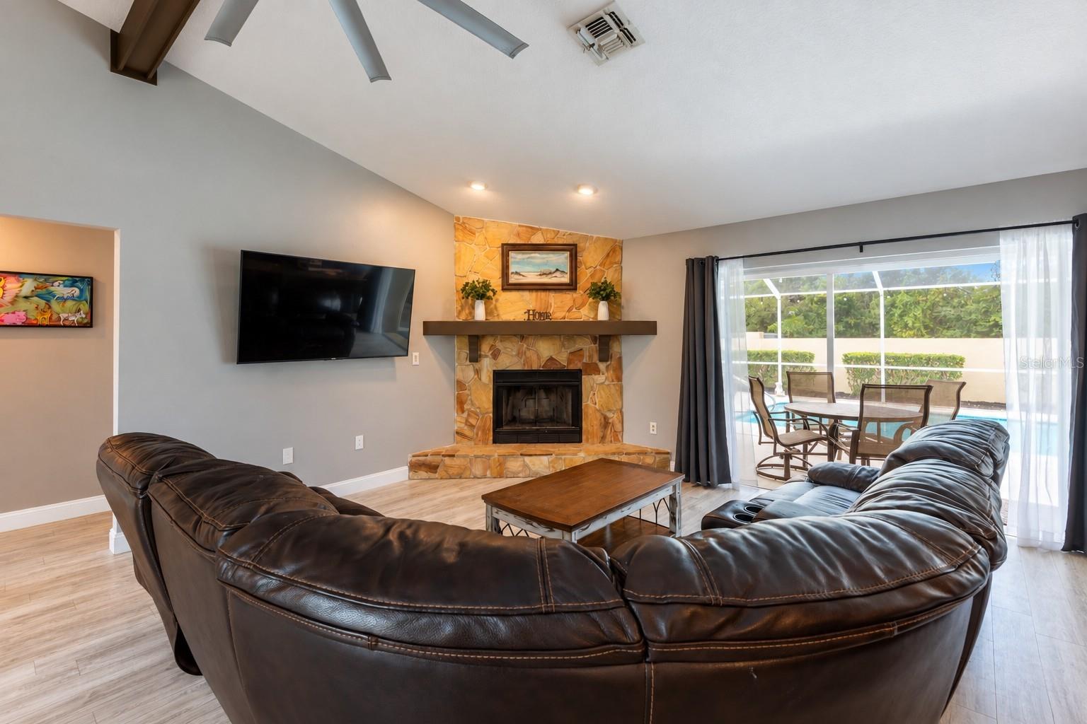 Great room with a wood burning fireplace and the sliding doors are recessed open to bring the inside and outside together. Great room with a wood burning fireplace and the sliding doors are recessed open to bring the inside and outside together.