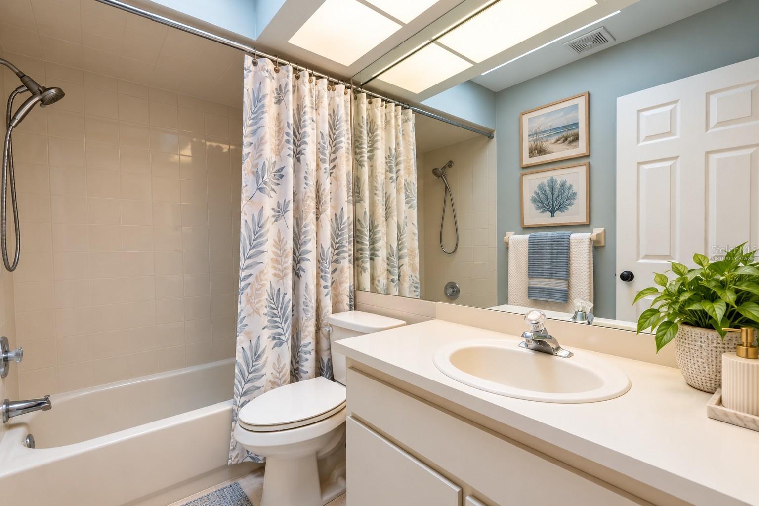 Bathroom shared by second and third bedrooms with virtually staged decor.