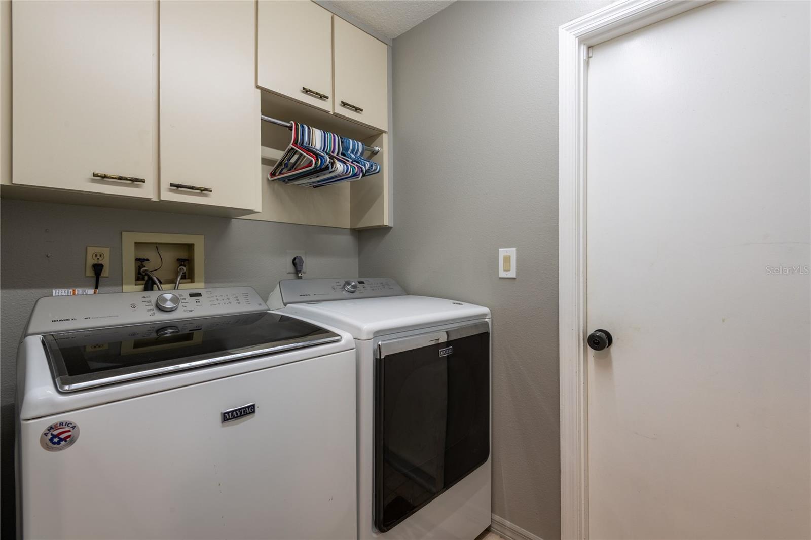 Laundry room with storage cabinets that lead to the garage.