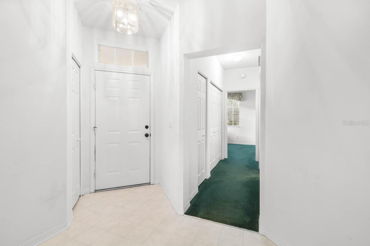 Entry way from inside the front door and view of hallway to guest bath and guest bedroom