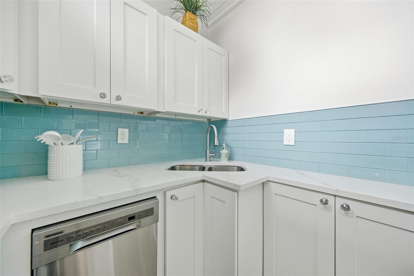 Shaker cabinets, dishwasher and seaglass backsplash