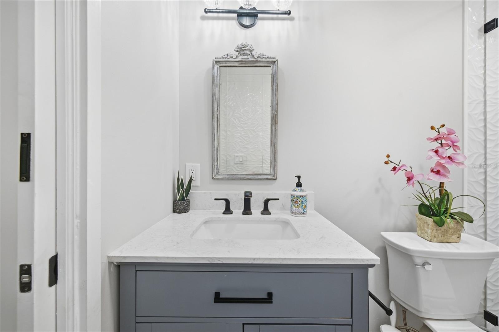Quartz vanity and striking matte-black accents.