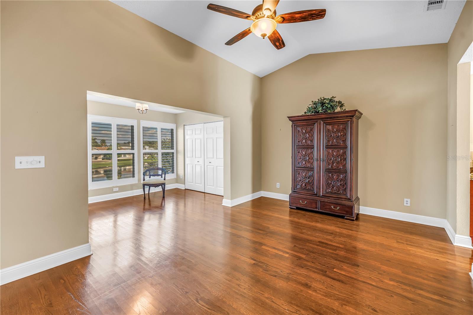Spacious primary bedroom featuring vaulted ceilings and an elegantly enclosed porch with two additional closets. This room offers magnificent lake views and provides an ideal space for a home gym, a quiet reading nook, or a nursery.