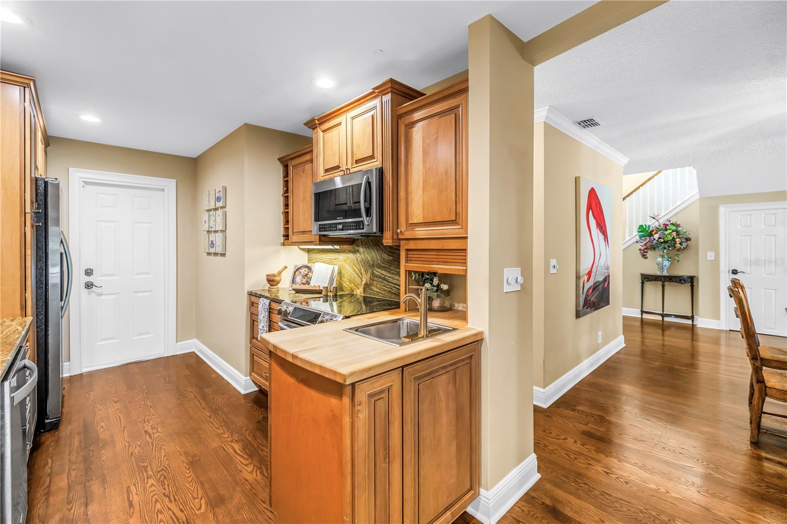 The kitchen features an efficient workspace equipped with a range, a convection microwave, and a preparation sink with an integrated butcher block countertop.