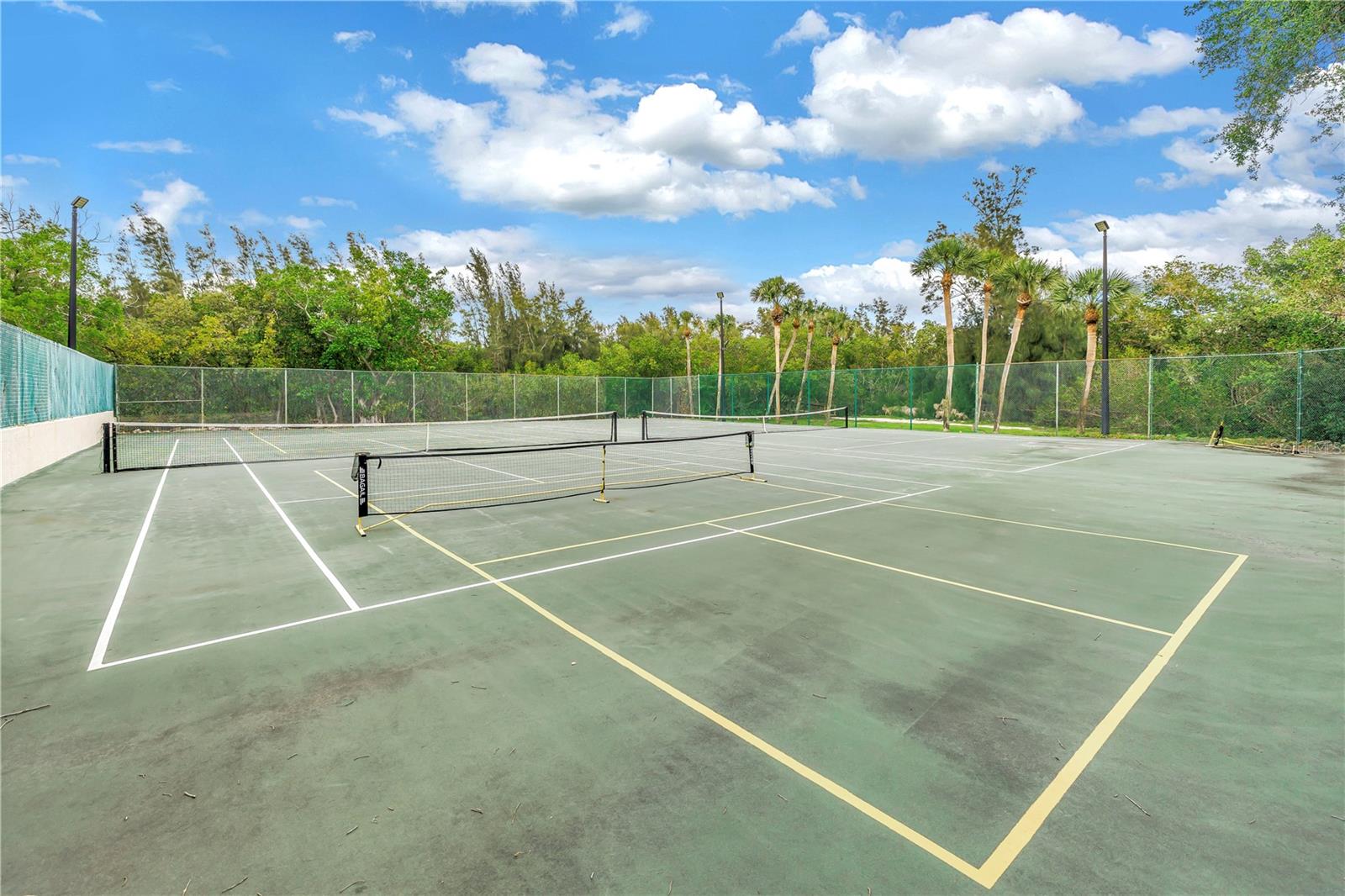 These two pickleball courts are easily accessible for day or night play and feature full lighting. The property also includes a tennis court.