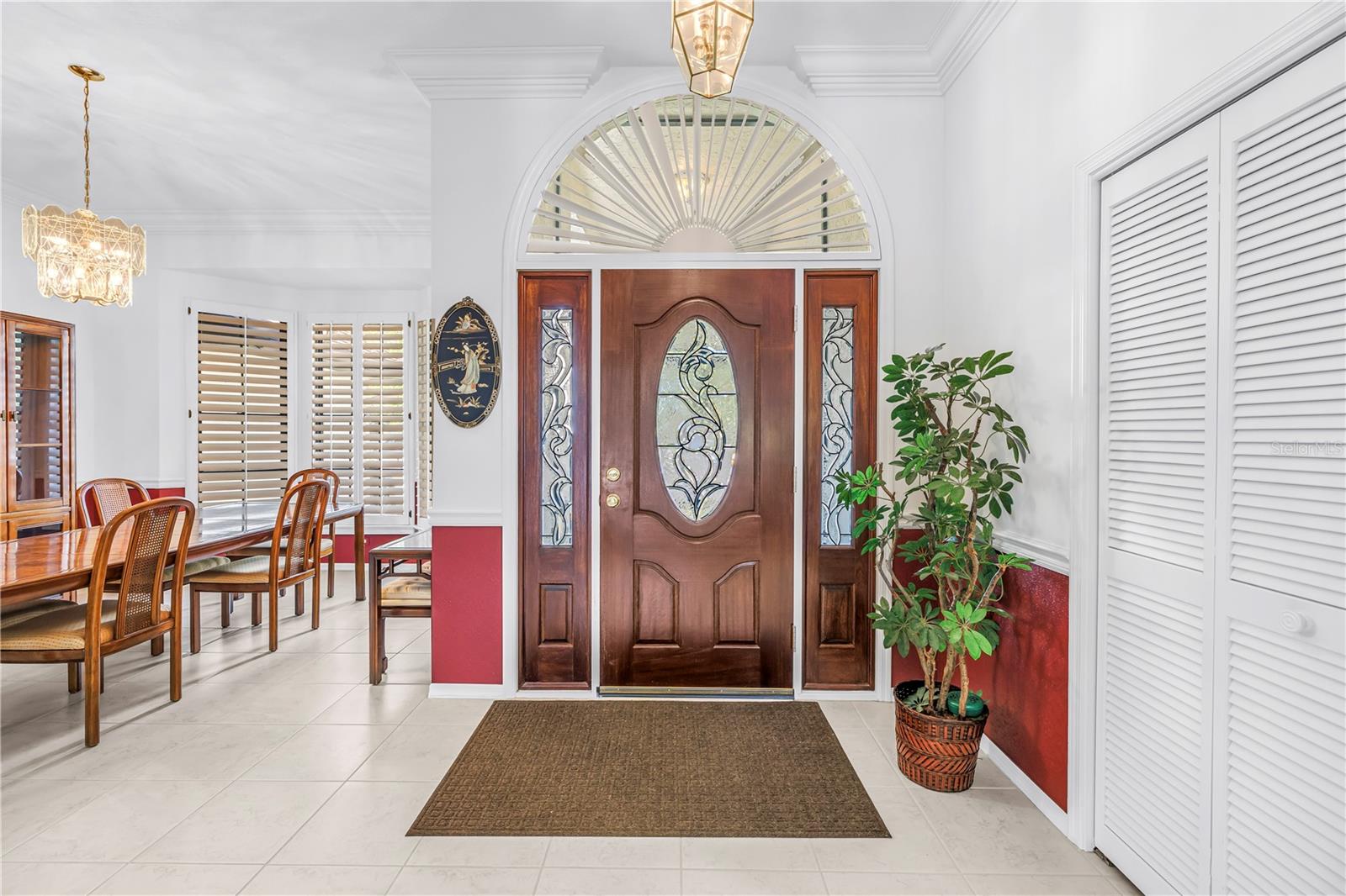 Foyer and adjacent formal dining room featuring abundant natural light and oversized windows.