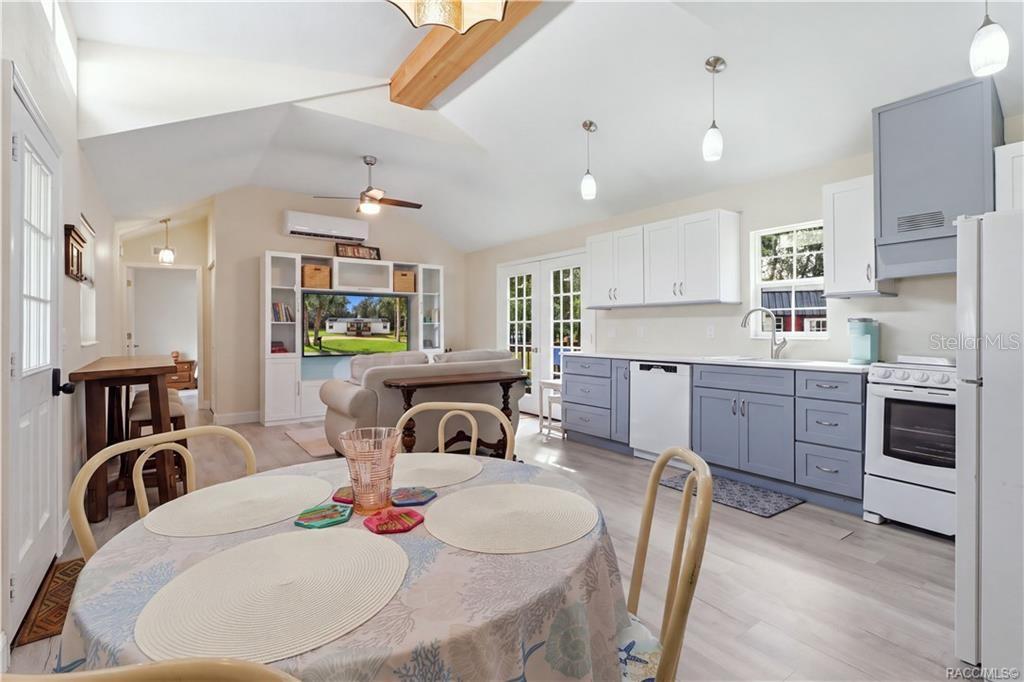 Open Living & Kitchen Area  Light-filled OPEN FLOOR PLAN featuring VAULTED CEILINGS, attractive flooring, pendant lighting & a beautifully coordinated kitchen.