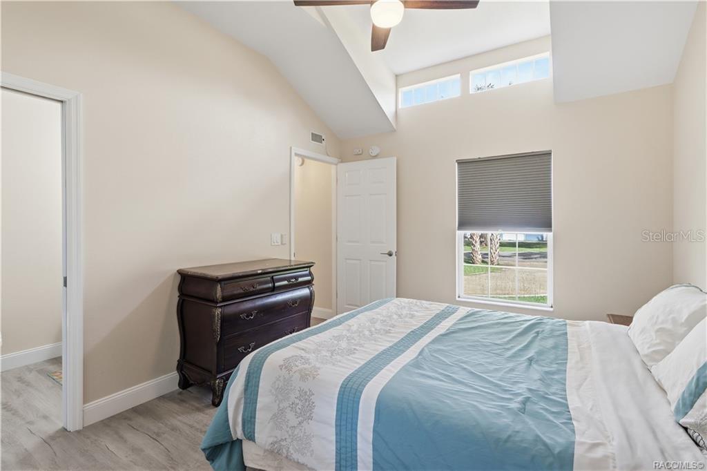 Primary Bedroom  Another view of the cheerful bedroom showcasing its VAULTED CEILINGS, upper transom windows, natural light & comfortable layout.