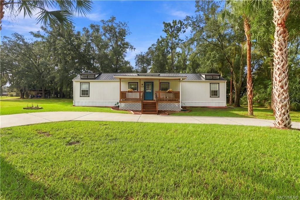 Charming Front Exterior Beautifully presented home featuring a METAL ROOF, inviting COVERED FRONT PORCH, attractive landscaping & a welcoming blue front door. Charming Front Exterior Beautifully presented home featuring a METAL ROOF, inviting COVERED FRONT PORCH, attractive landscaping & a welcoming blue front door.