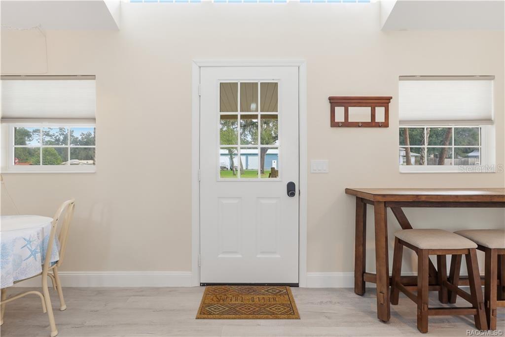 Front Entry  Bright & welcoming entrance featuring a glass-paneled front door, natural light, attractive flooring & space for additional seating.