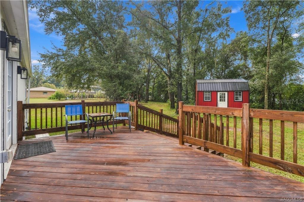 Rear Deck  Step outside & enjoy the spacious WOODEN REAR DECK overlooking the backyard! A wonderful spot for morning coffee, outdoor conversation or relaxing beneath the surrounding trees.