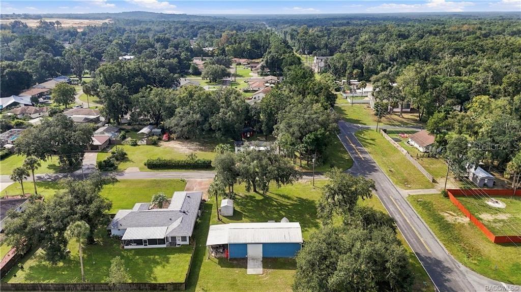 Neighborhood Aerial View  Wide aerial perspective capturing the surrounding neighborhood, tree-lined streets & established residential setting.