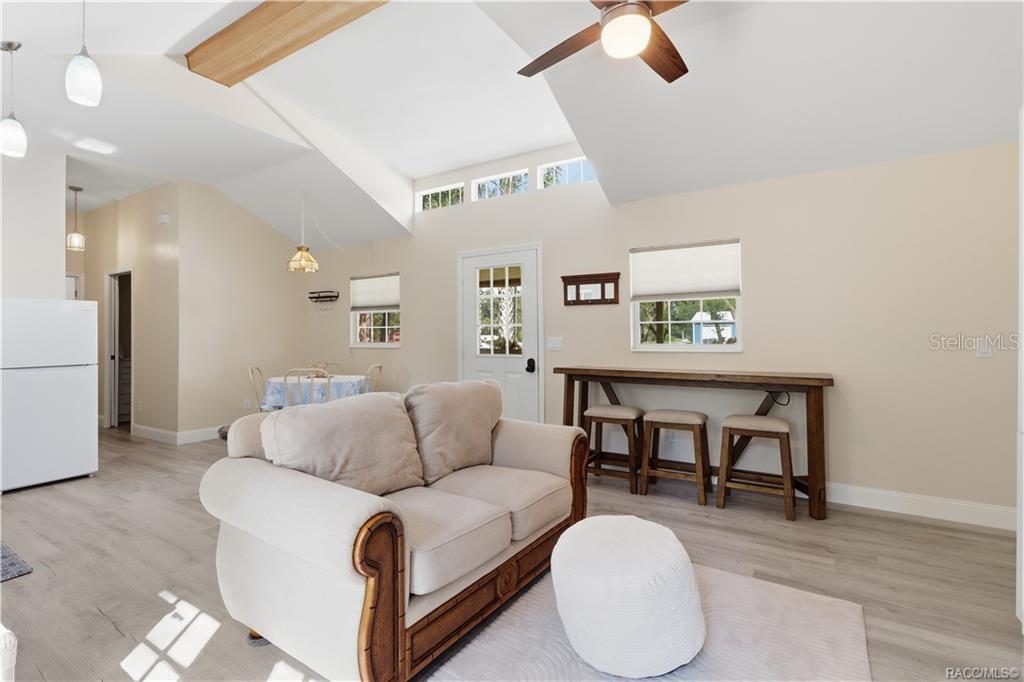 Open Floor Plan  Natural light fills this cheerful living space featuring VAULTED CEILINGS, decorative wood beam, clerestory windows & a convenient breakfast bar area. An inviting place to relax or gather!