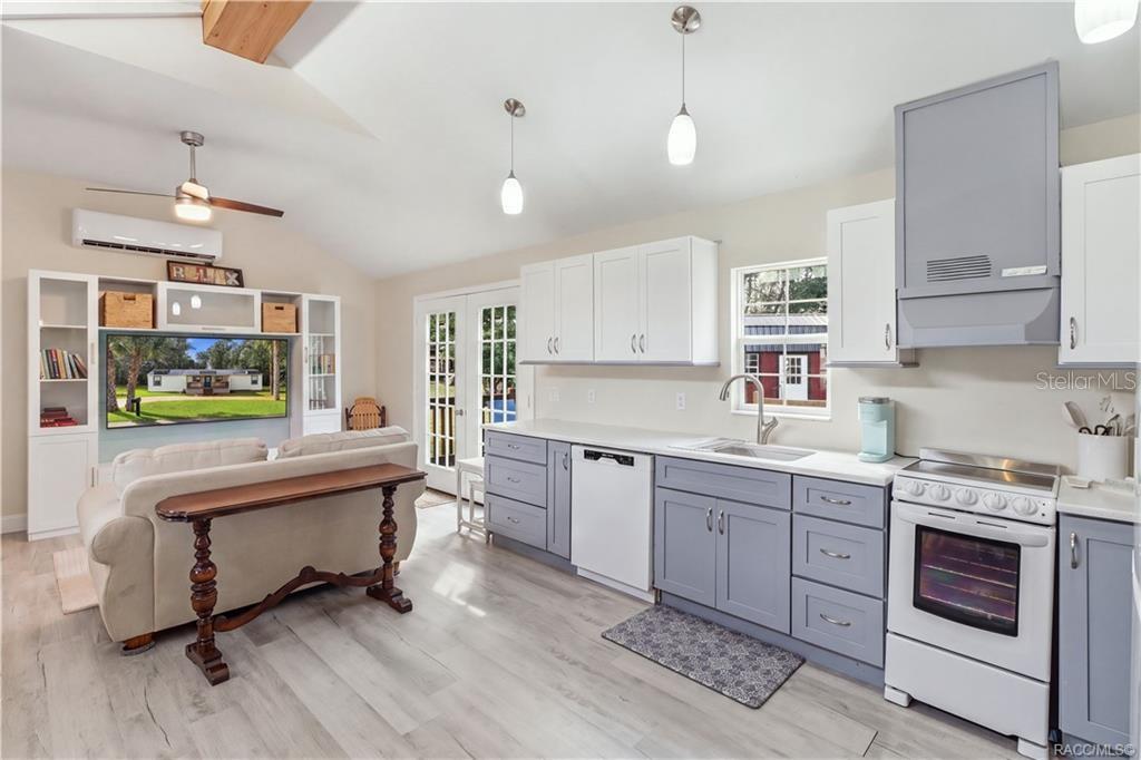 Kitchen & French Doors Bright kitchen featuring white upper cabinetry, soft blue-gray lower cabinetry, SOLID SURFACE COUNTERTOPS & French doors leading to the outdoor deck. Kitchen & French Doors Bright kitchen featuring white upper cabinetry, soft blue-gray lower cabinetry, SOLID SURFACE COUNTERTOPS & French doors leading to the outdoor deck.