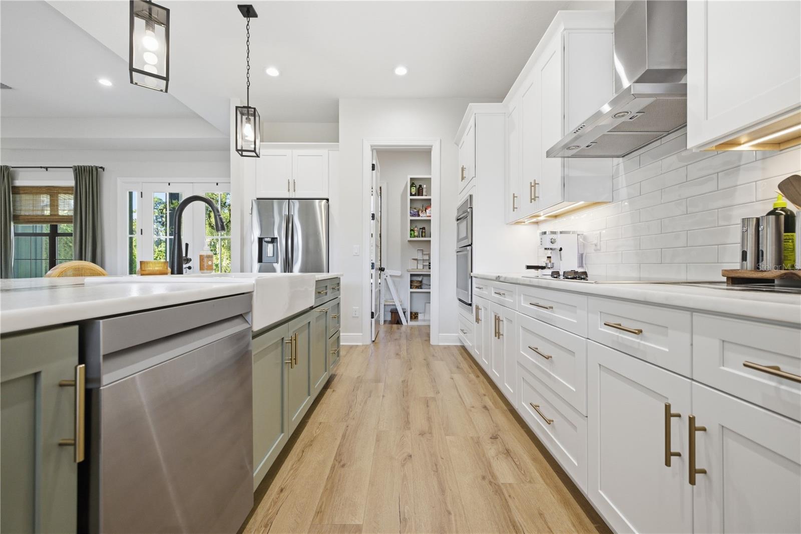 custom cabinetry with 36 inch electric cooktop and sage green oversized island.