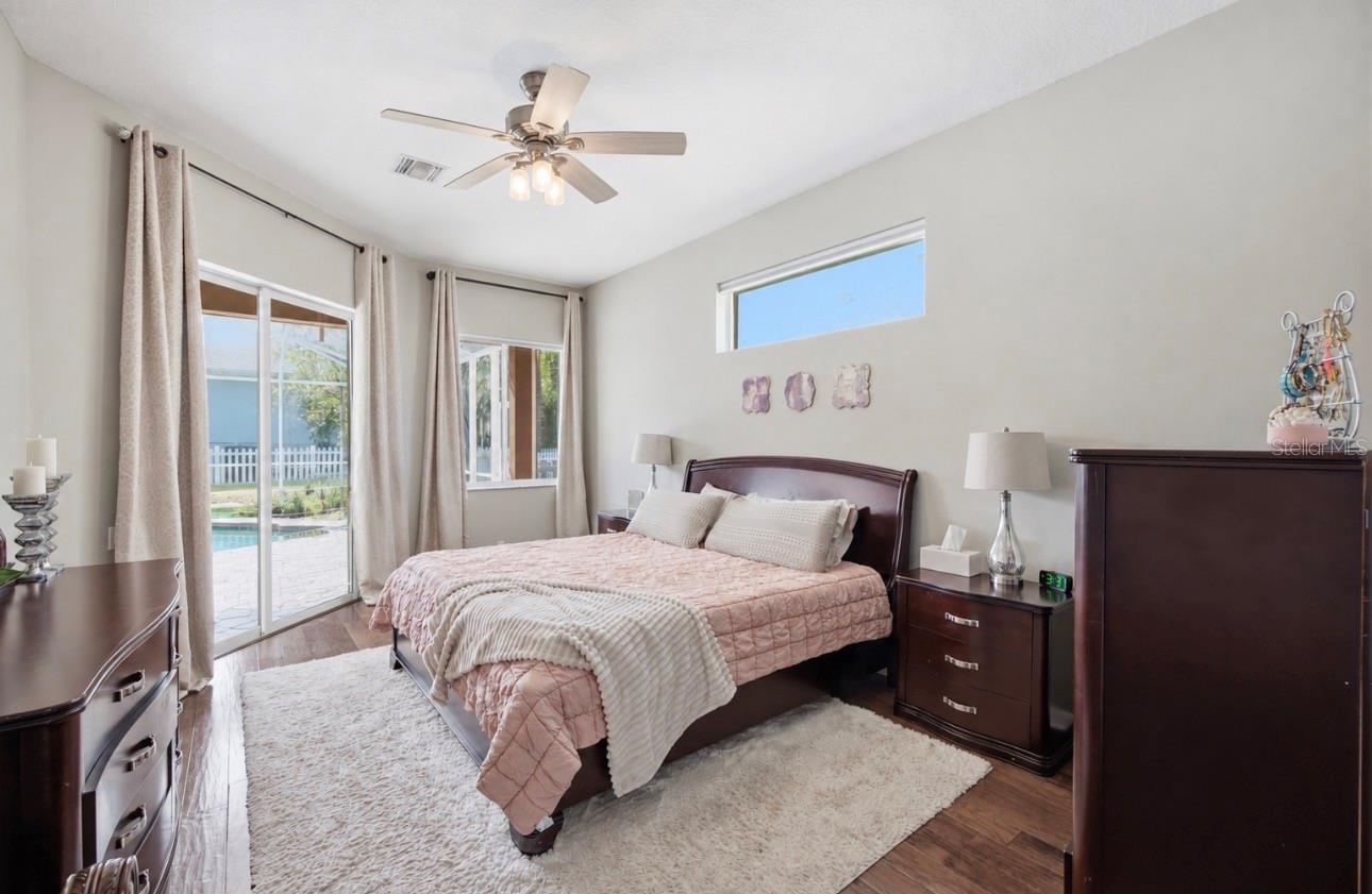 Primary Suite with sliders out to the pool area, high ceilings, huge walk in closet, huge bathroom, and storage.