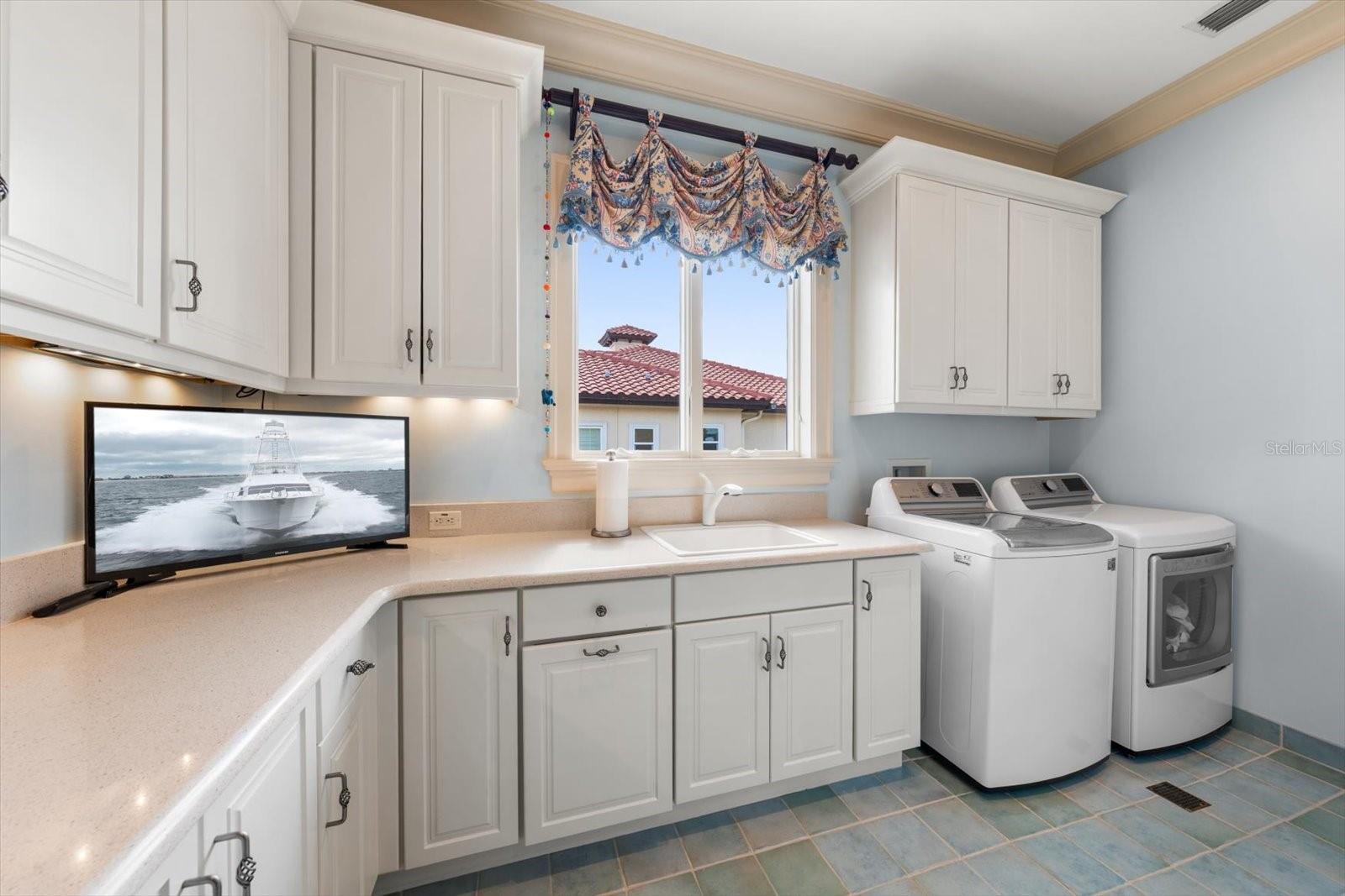 Oversized Laundry Room with stairs leading to attic space for even more storage!