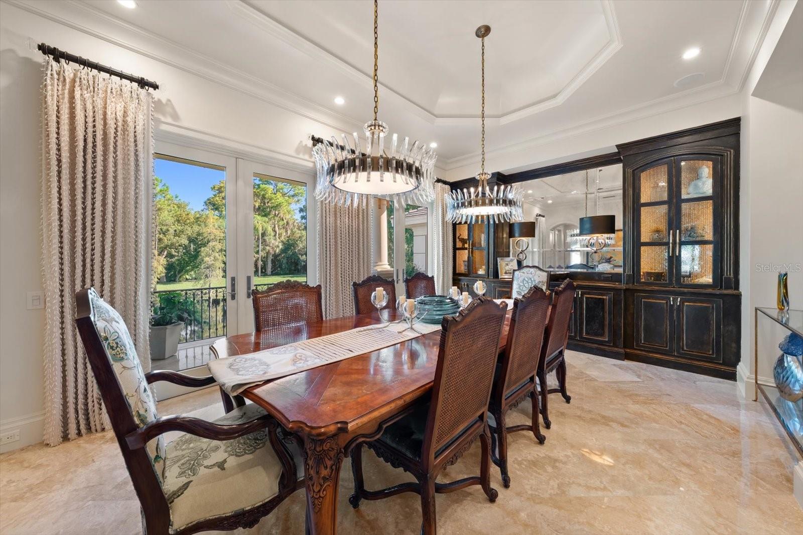 A formal dining room overlooking the lake and natural surroundings