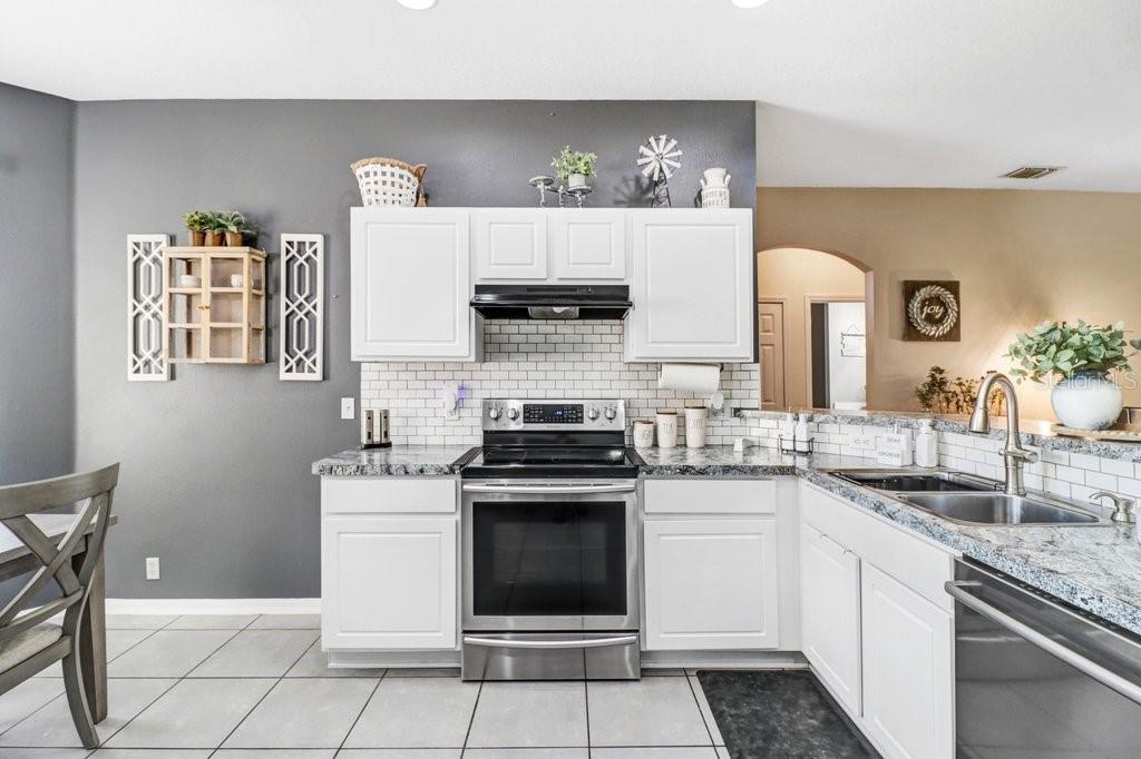 Kitchen with stainless appliances, granite and beautiful backsplash Kitchen with stainless appliances, granite and beautiful backsplash