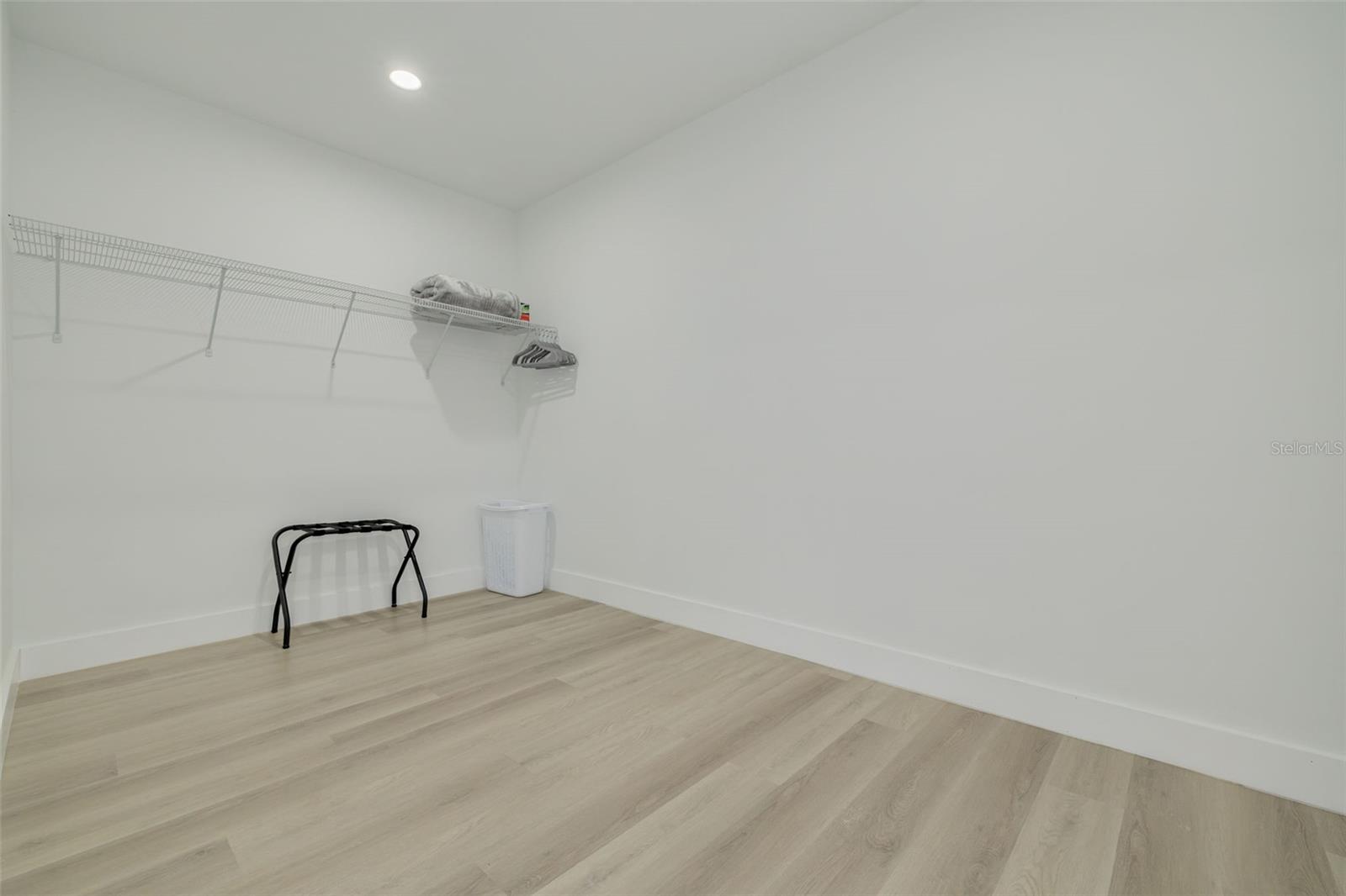 Large walk in closet with a section for a large built-in safe on the right side.