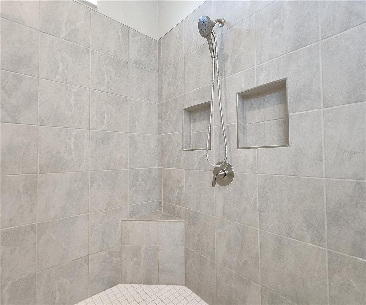 Master bathroom includes large walk-in  tiled shower, water closet, walk-in closet, dual sink vanity, granite countertops