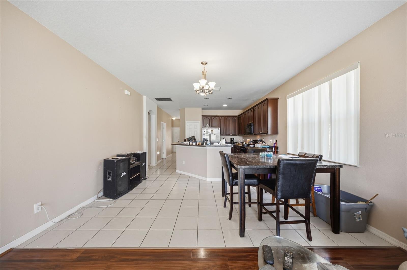 Nook and kitchen viewed from family room, with long tiled walkway to foyer