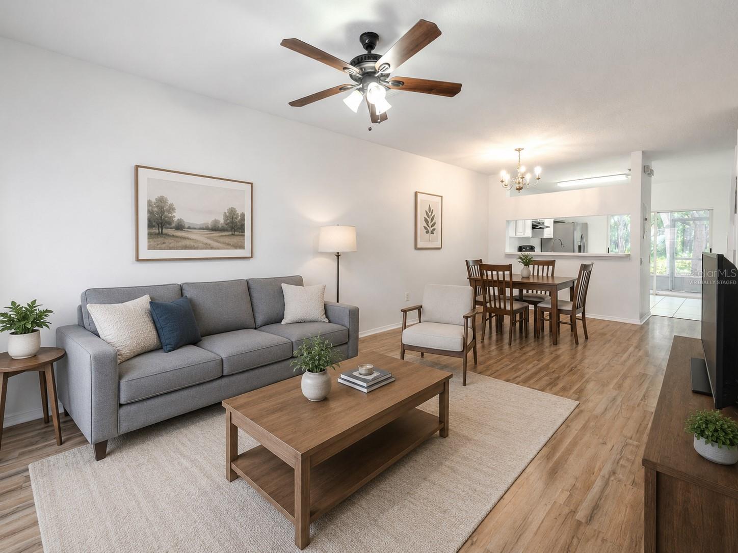 The Living room features neutral tones, wood laminate flooring, a ceiling fan with light kit and picture window. (Photo has been virtually staged.) The Living room features neutral tones, wood laminate flooring, a ceiling fan with light kit and picture window. (Photo has been virtually staged.)