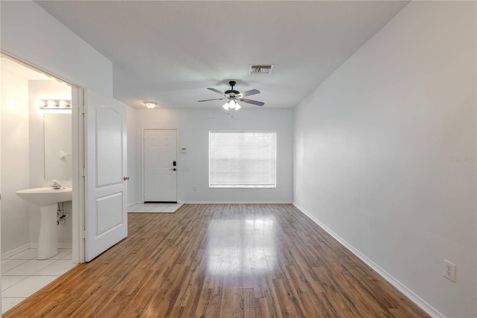 The Living room features neutral tones, wood laminate flooring, a ceiling fan with light kit and picture window. The Living room features neutral tones, wood laminate flooring, a ceiling fan with light kit and picture window.