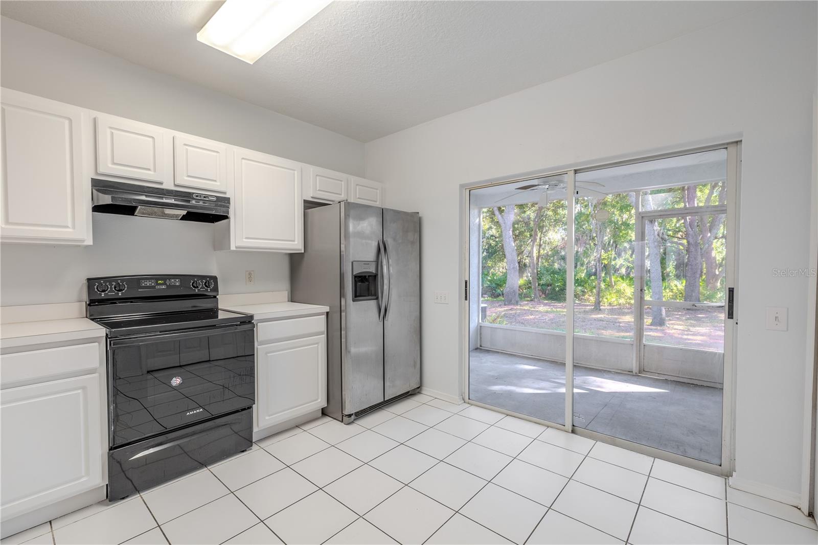 The kitchen features neutral tone cabinets and countertops, and a stainless steel dishwasher. There is a laundry closet with washer/dryer.