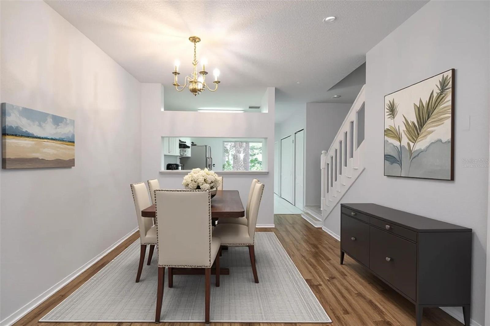 Dining room features wood laminate flooring, a 6 light chandelier and a convenient pass thru to the kitchen. (Photo has been virtually staged.) Dining room features wood laminate flooring, a 6 light chandelier and a convenient pass thru to the kitchen. (Photo has been virtually staged.)