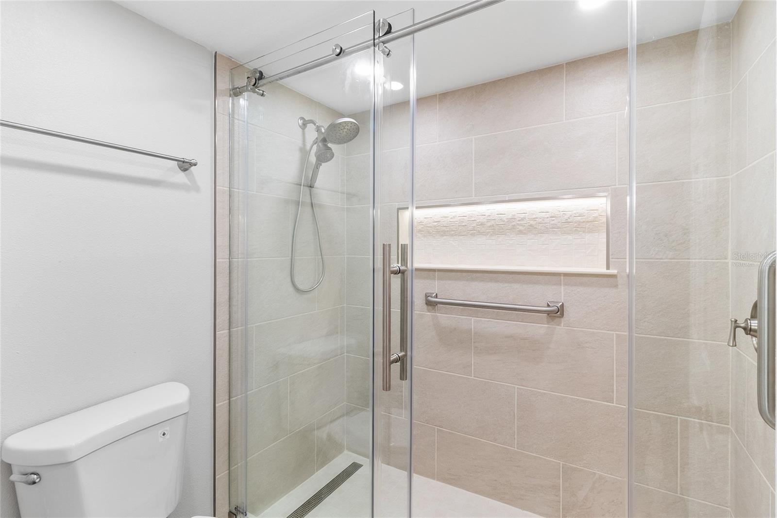 VIRTUALLY STAGED primary bath with updated tile and enclosure