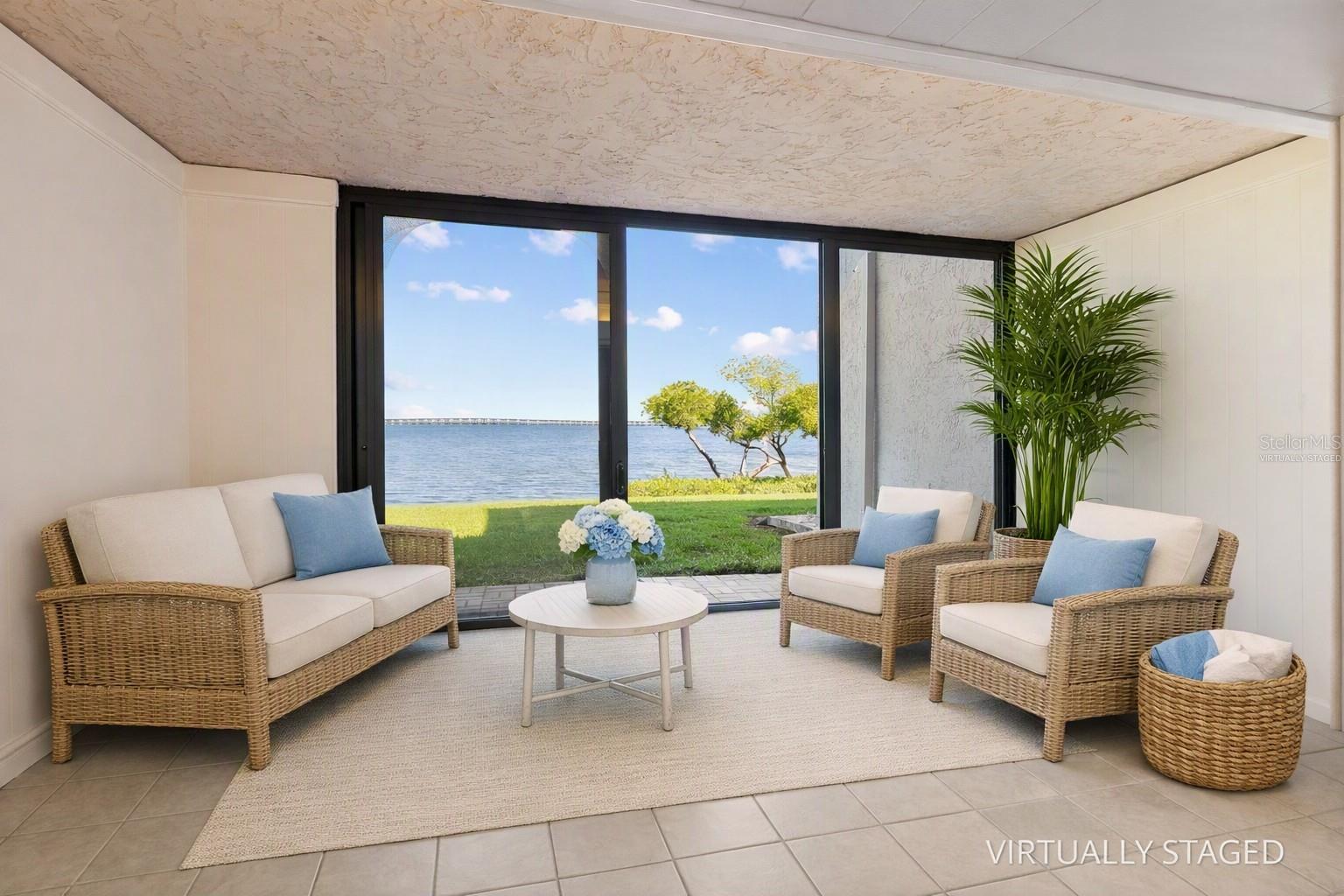 Virtually staged sunroom with full water view.