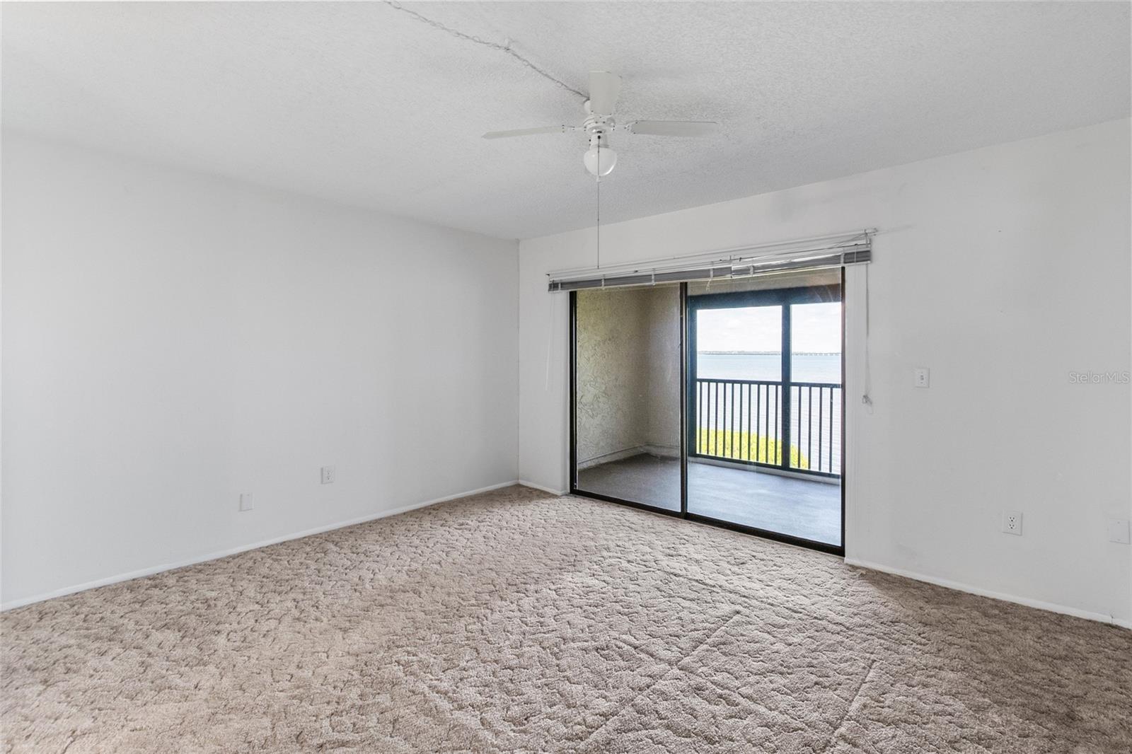 Primary bedroom - looking towards the private balcony with panoramic water views.