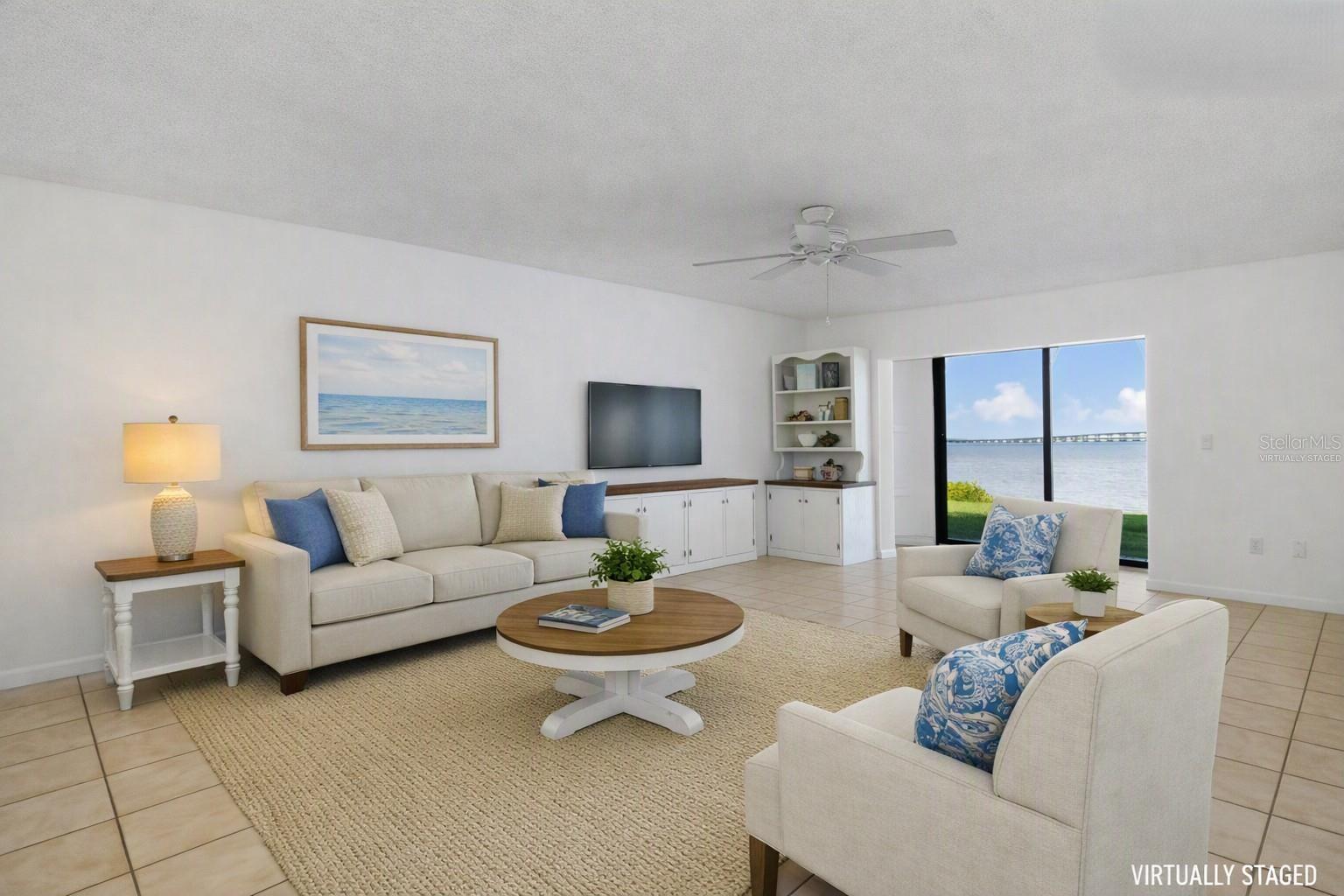 Virtually staged living area with different wall finish - overlooking water view.