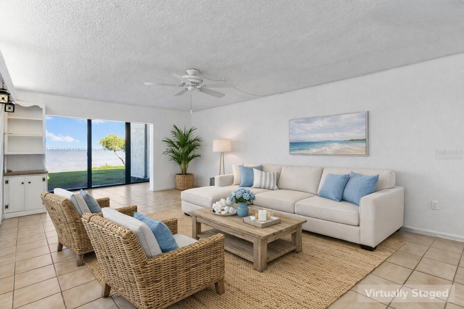 Virtually staged living area looking toward water view.