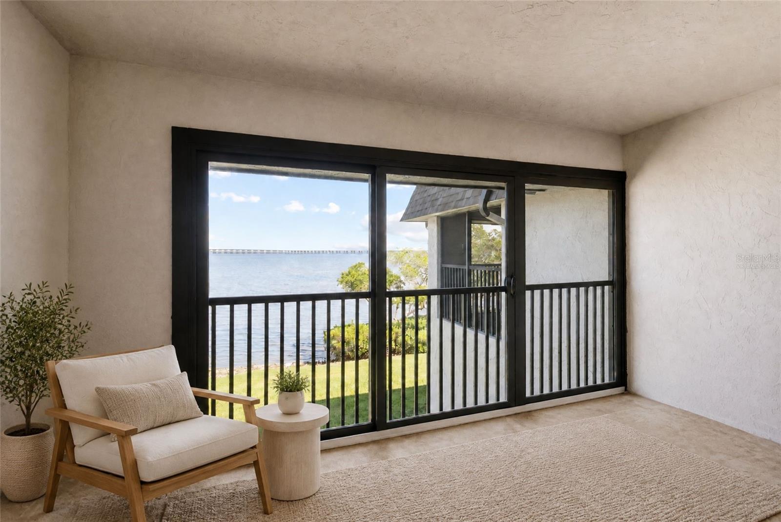 Virtually staged balcony off primary bedroom with panoramic water views