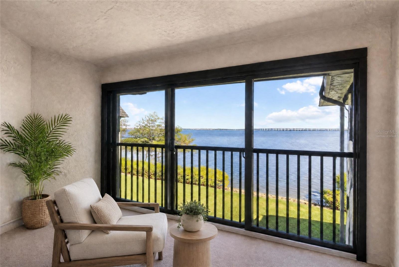 Virtually staged - primary bedroom balcony with water view