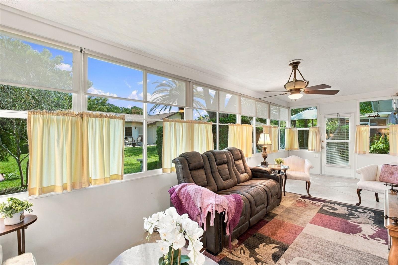 Massive Florida room located at the rear of the home surrounded by large windows with peaceful green views~