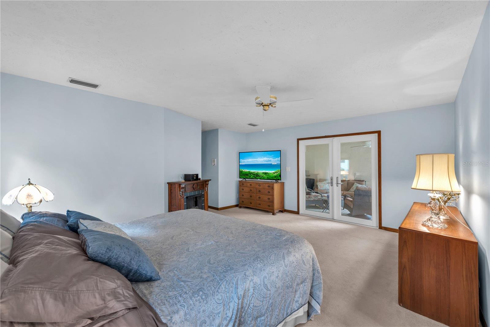 The expansive primary suite is a retreat of its own, complete with French doors opening directly to the screened lanai.