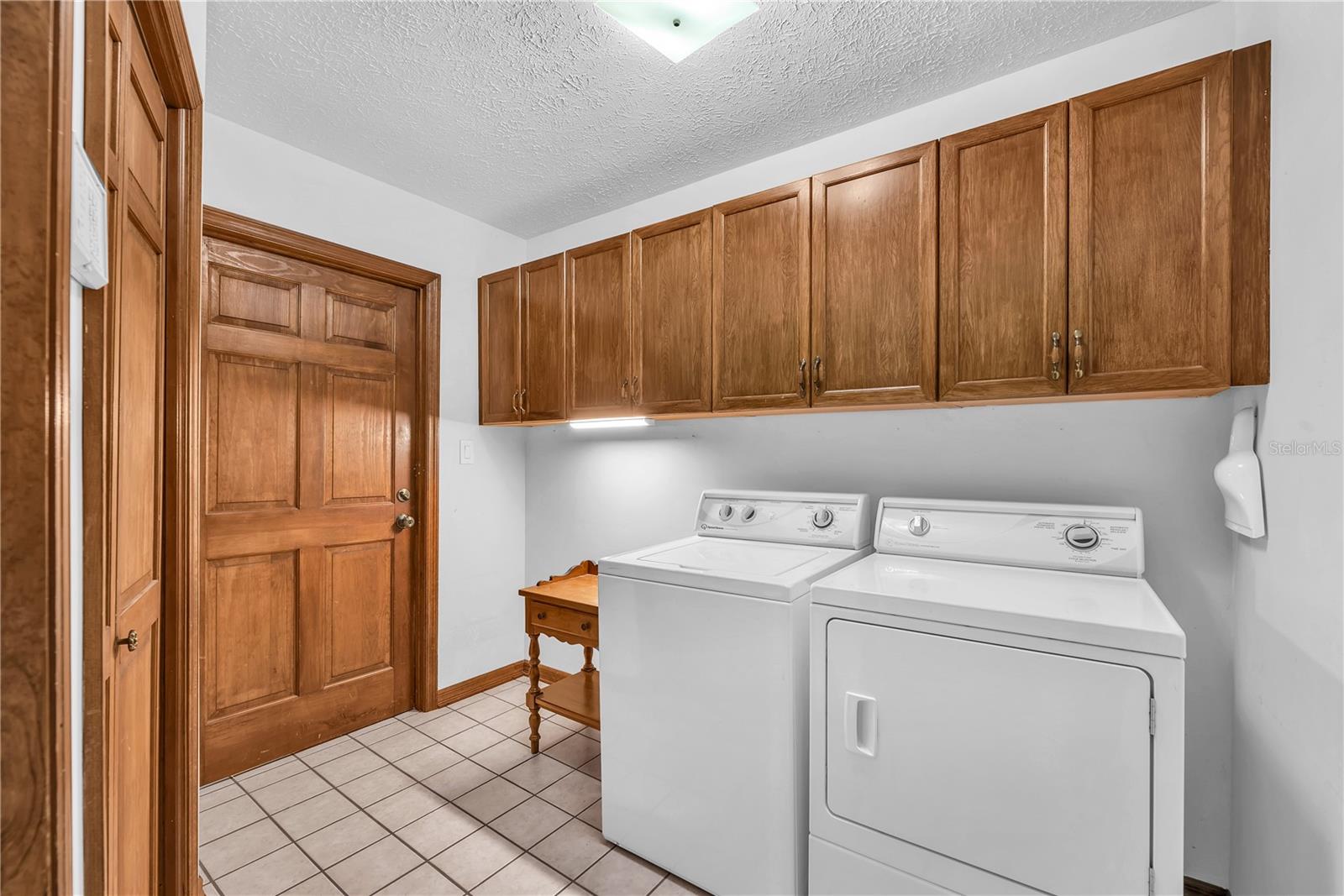 Spacious Laundry room with lots of cabinet storage and garage access.