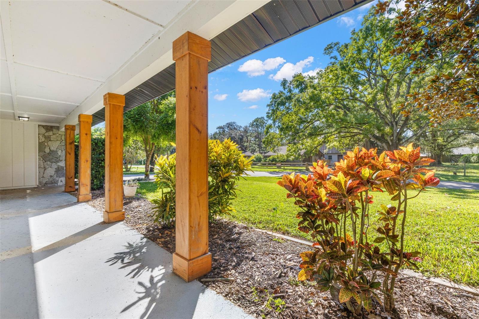 The expansive covered front porch offers a shaded spot to relax, enjoy your morning coffee, or unwind while overlooking the beautifully landscaped front lawn and mature shade trees.