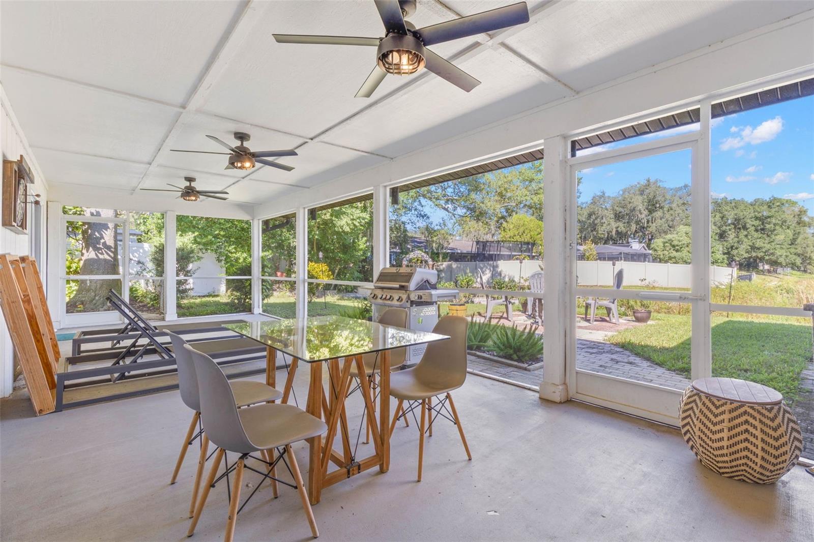 Enjoy outdoor dining year-round on the expansive screened porch, complete with three ceiling fans, room for comfortable seating, and a convenient screen door leading to the backyard and adjoining patio. An ideal setting for casual meals, entertaining, or simply enjoying the fresh air.