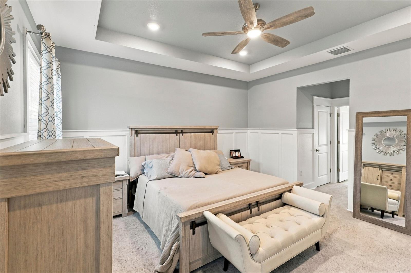 Primary Bedroom with Elegant Tray Ceiling and Ceiling Fan
