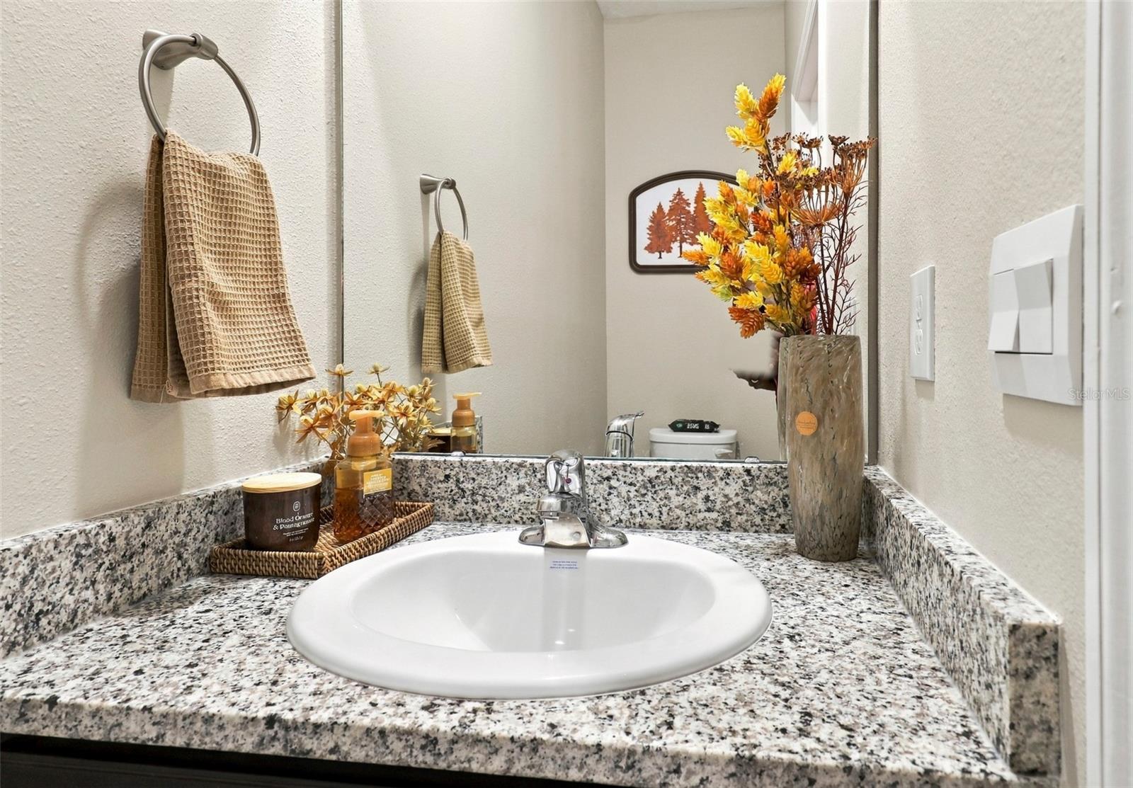 Half Bathroom Featuring Granite Style Countertop